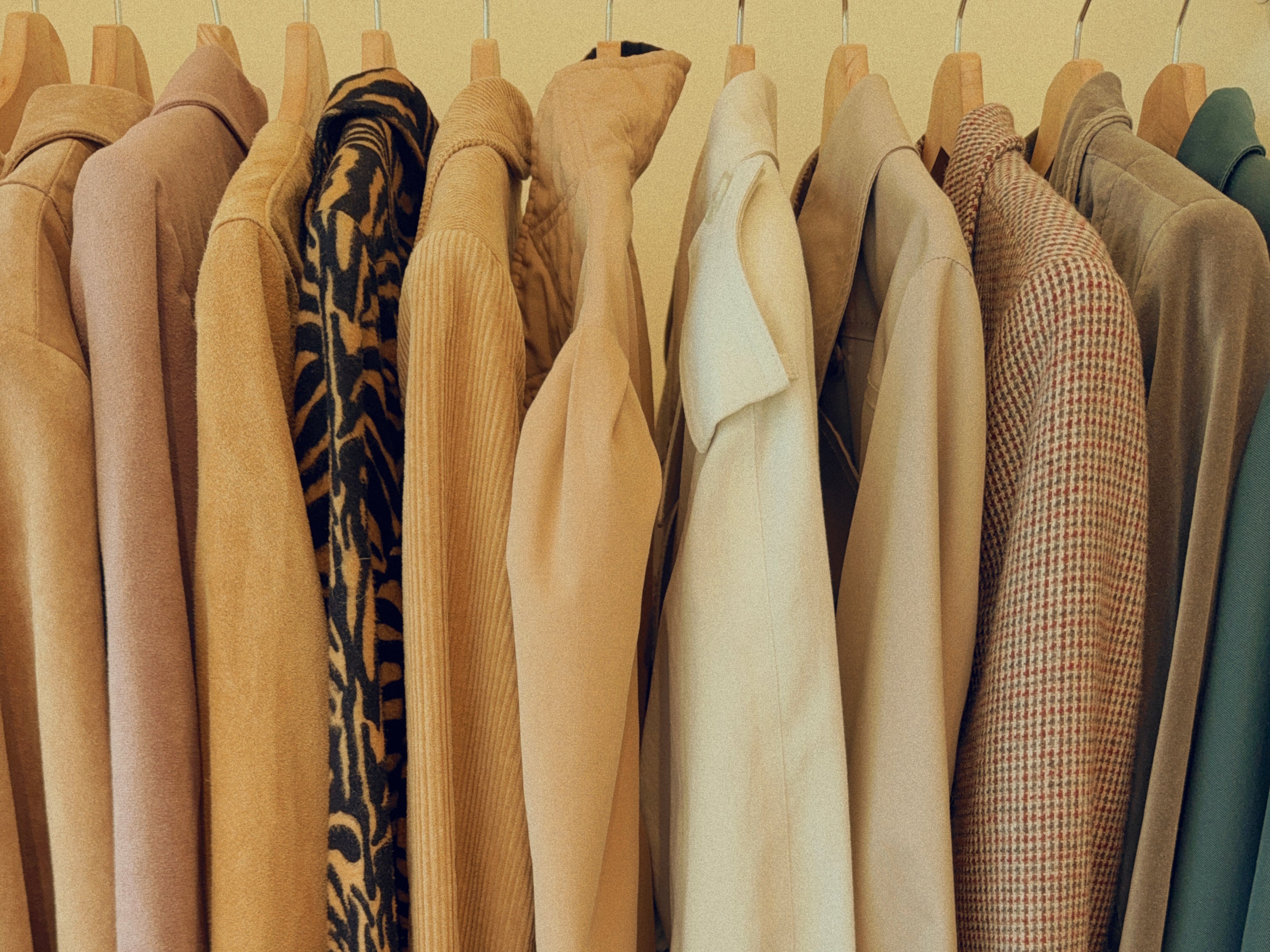 a rack of vintage trench coats, blazers, and jackets at Retrolocal